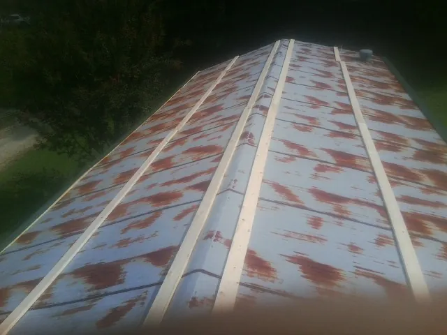 Rusted metal roof panels with new wood purlins before replacement — Storm Damage Roof Repair in Lander by Roofing Brothers