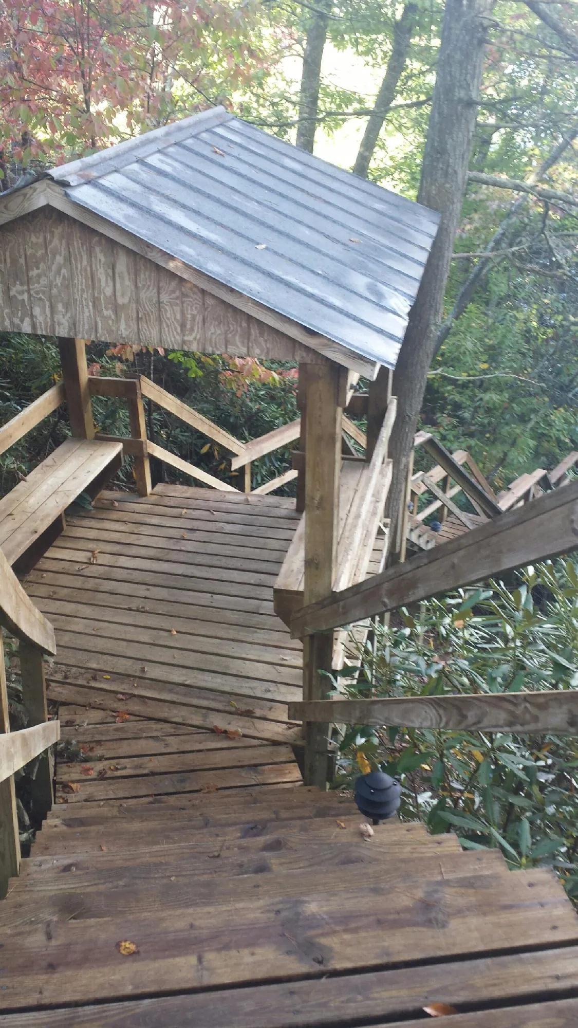 Metal roofed shelter over wooden steps on a wooded walkway in Lander