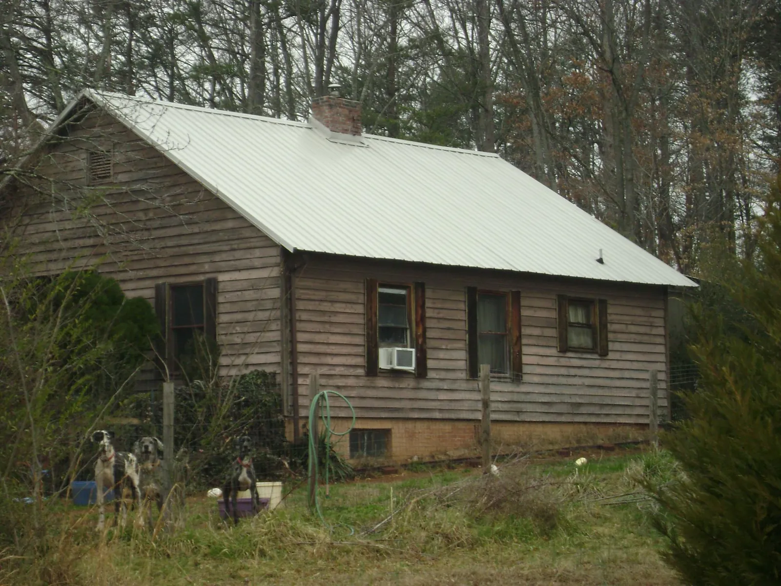 White metal roof on an old wood sided farmhouse, from a Metal Roof Installation job in Lander